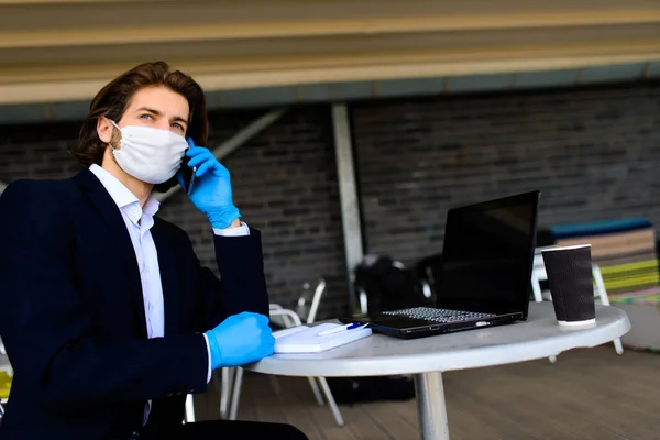 Young man in a medical mask outside, no money, crisis, poverty, hardship, isolation.