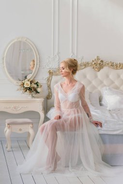 Kavramsal düğün, gelinin Avrupa tarzında bir sabah. İç stüdyoda özel bir elbise var. Gelin için beyaz minimalizm