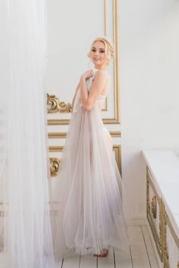 Kavramsal düğün, gelinin Avrupa tarzında bir sabah. İç stüdyoda özel bir elbise var. Gelin için beyaz minimalizm