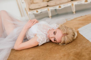 Kavramsal düğün, gelinin Avrupa tarzında bir sabah. İç stüdyoda özel bir elbise var. Gelin için beyaz minimalizm