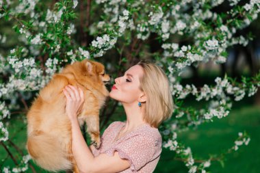 Pomeranya tükürüğünü kucaklayan gülümseyen genç bir kadının yakın portresi.