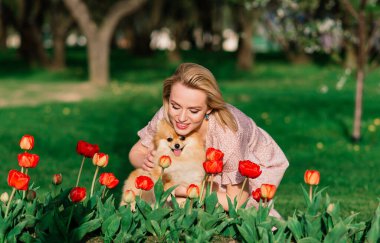 Pomeranya tükürüğünü kucaklayan gülümseyen genç bir kadının yakın portresi.