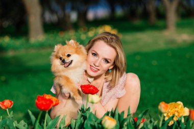 Pomeranya tükürüğünü kucaklayan gülümseyen genç bir kadının yakın portresi.