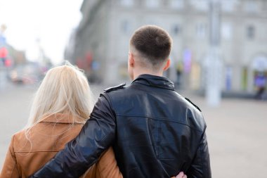 Koruyucu maskeli bir çift, karantina zamanında iş binasının yakınında şehir dışında yürüyüş yapıyor. Coronavirüs kavramı, covid.