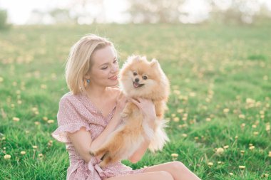 Pomeranya tükürüğünü kucaklayan gülümseyen genç bir kadının yakın portresi.