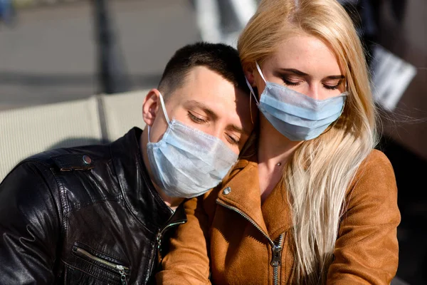 Young couple in love in protective medical mask on face outdoor at street. Guy and girl in virus protection.