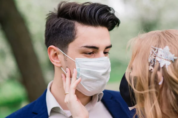 Düğün günlerinde karantina sırasında parkta maske takan genç bir çift. Coronavirus, hastalık, koruma, hastalık. Avrupa kutlamaları iptal edildi.