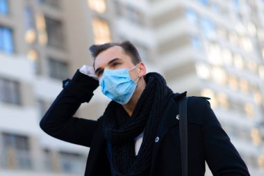 Yüz maskeli insanlar. Kopyalama alanı kavramı. Grip karantinasında yetişkin bir adamın portresi. Sokaktaki fotoğraf..