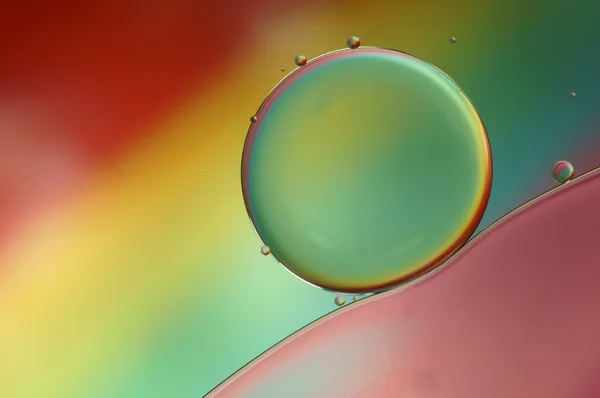 Las gotas de aceite sobre la superficie del agua - el arco iris abstracto de color macro (510 ) — Foto de Stock