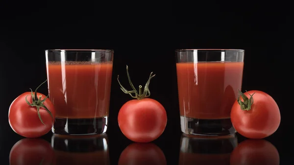 Stillleben mit Tomatensaft im Glas auf schwarzem Hintergrund — Stockfoto