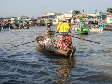 Bir kadın teknesini yüzen pazarda Mekong Nehri Deltası 'nda yüzdürüyor Cai Rang, Vietnam