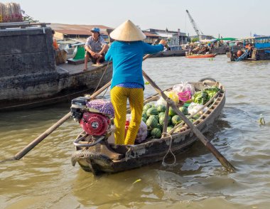 Bir kadın teknesini yüzen pazarda Mekong Nehri Deltası 'nda yüzdürüyor Cai Rang, Vietnam