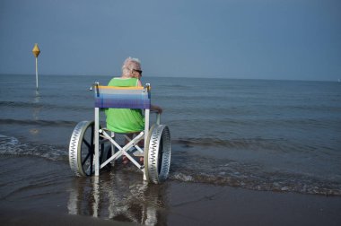 elderly woman in a wheelchair in the sea clipart