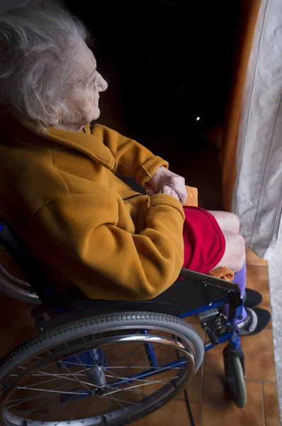 Vecchia donna che guarda in una finestra — Foto Stock