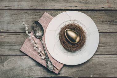 Golden Easter egg on plate  clipart