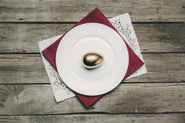 皿の上の黄金のイースターエッグ — ストック写真