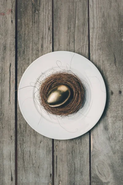 Golden Easter egg on plate — Stock Photo, Image