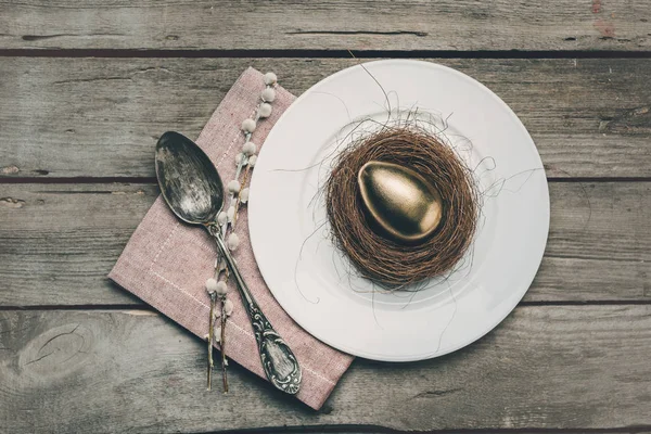 Œuf de Pâques doré sur assiette — Photo