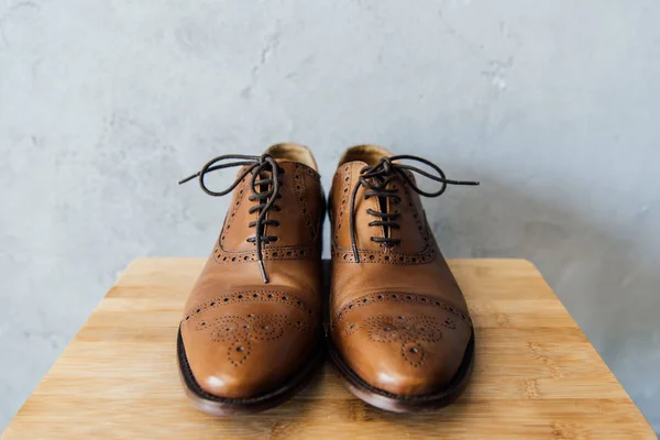 Sapatos oxford marrom em banquinho de madeira — Fotografia de Stock