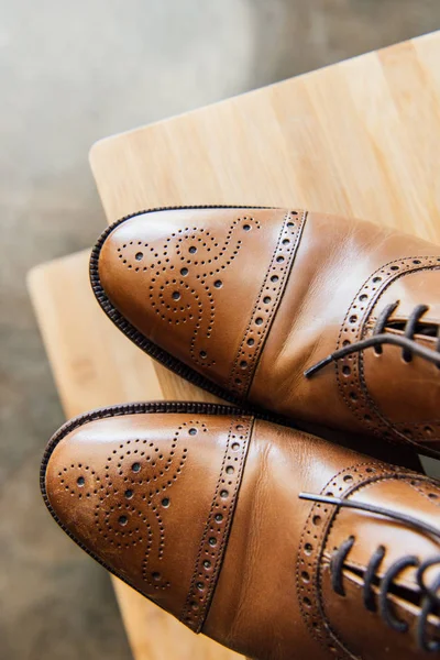 Коричневе взуття на дерев'яному табуреті — стокове фото