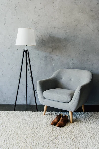Взуття окфорд біля текстильного крісла та лампи — стокове фото