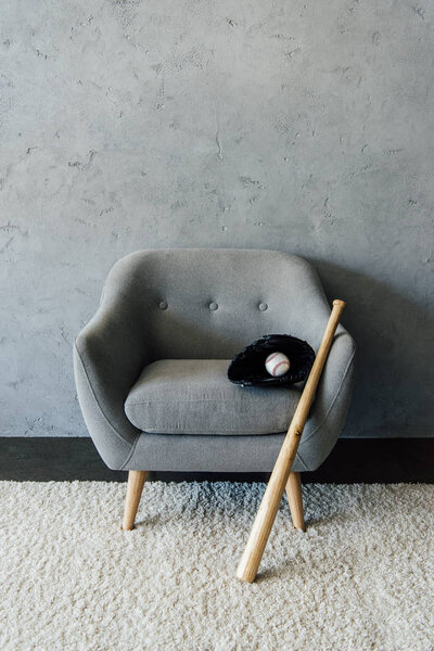 baseball bat and ball with glove on armchair