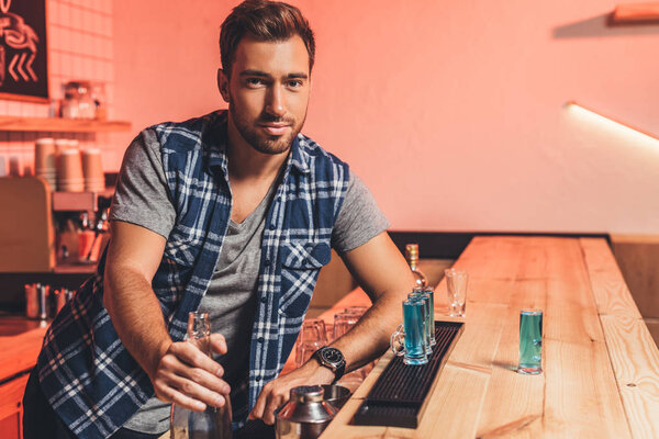 barman with alcohol shots on counter