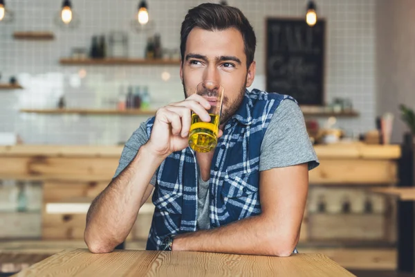 Мужчина пьет сок в кафе — Бесплатное стоковое фото