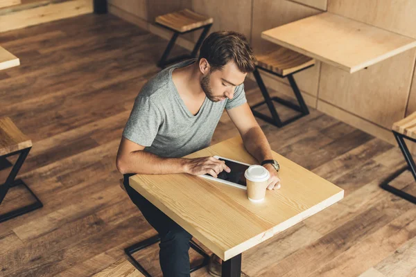 Человек с планшетом в кафе — стоковое фото