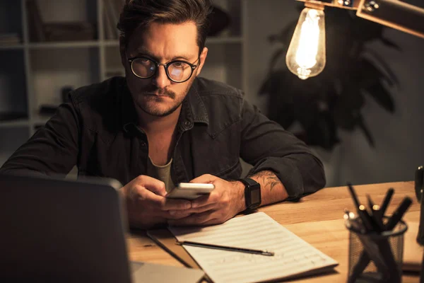 Thoughtful composerusing smartphone — Stock Photo, Image