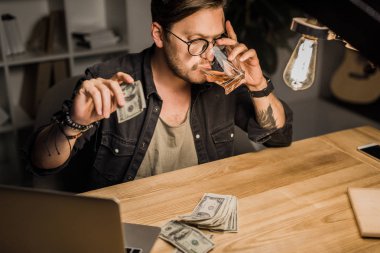 adam para yığını ile viski içme