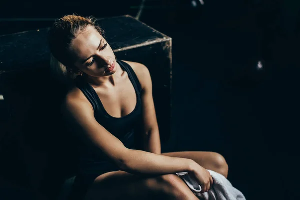 Exhausted sportswoman sitting on floor — Stock Photo, Image