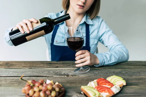 Sommelier versant du vin rouge dans un verre — Photo