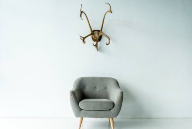 armchair and antlers on wall clipart