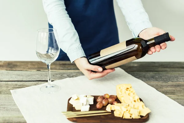 Сомелье смотрит на бутылку белого вина — стоковое фото