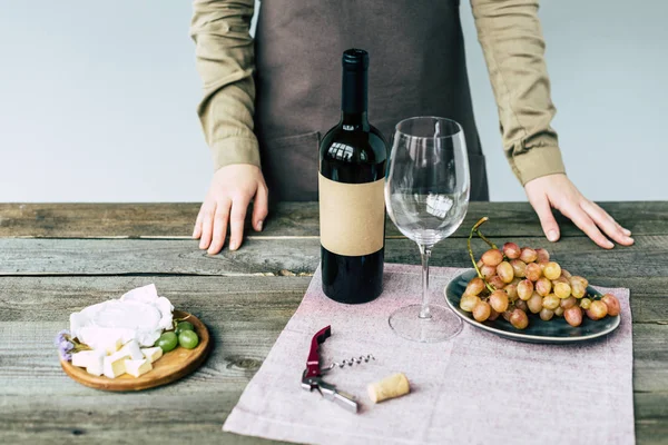 Sommelier de pé perto da mesa com vinho — Fotografia de Stock