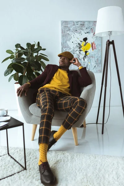 fashionable man sitting in armchair