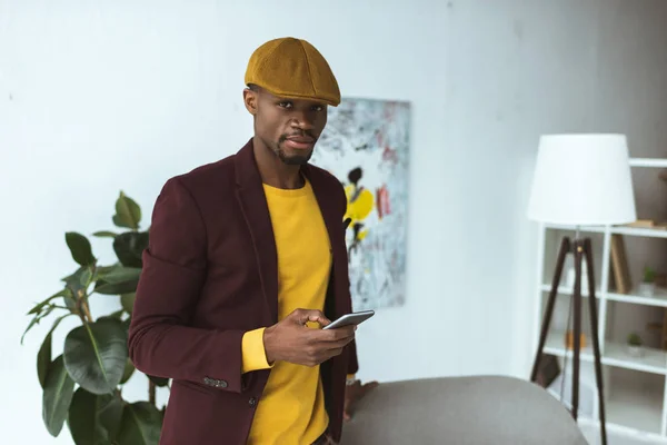 Hombre con gorra usando smartphone — Foto de Stock