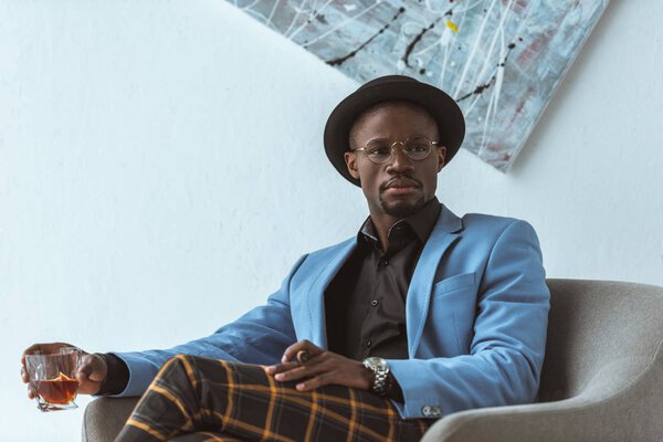 Красивый мужчина с сигарой и виски
