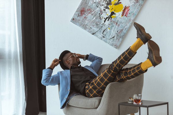 стильный человек в офисе с росписью на стене
