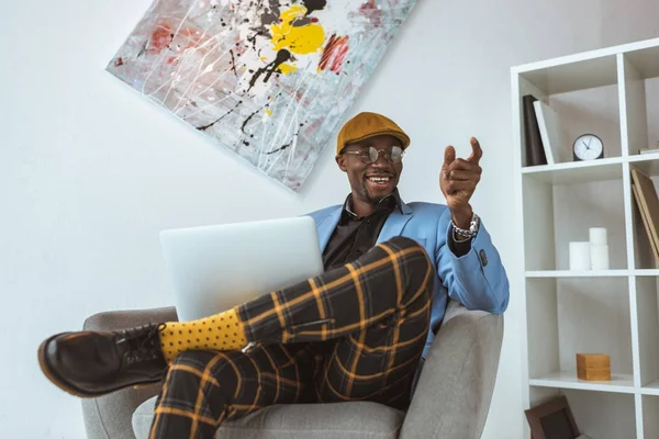 Homem de negócios gesticulando ao usar laptop — Fotografia de Stock