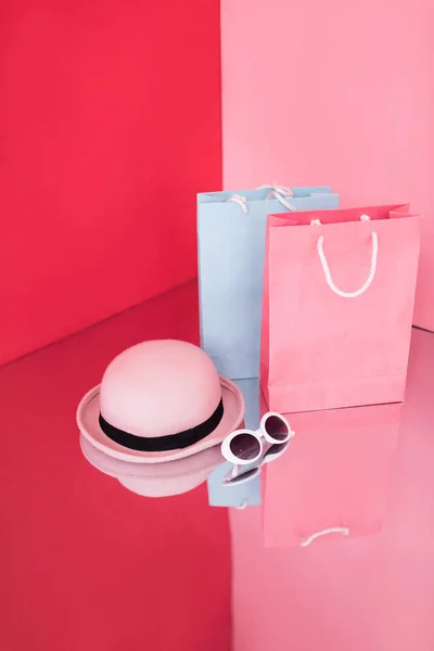 Sacos de compras, chapéu e óculos de sol — Fotografia de Stock