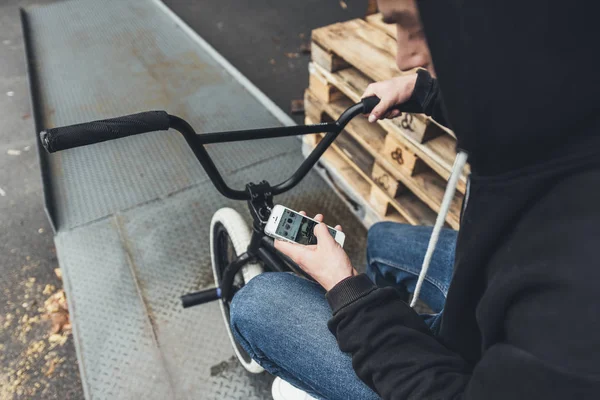 BMX motoros használ smartphone — Stock Fotó