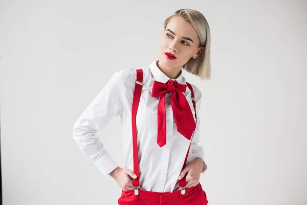 Stylish girl in red suspenders and bow — Stock Photo, Image