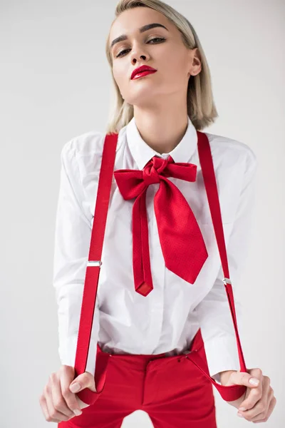 Girl posing in red suspenders and bow — Stock Photo, Image