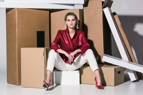 Fashionable girl on cardboard boxes — Stock Photo, Image
