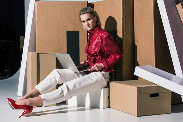 Chica usando el ordenador portátil en cajas —  Fotos de Stock