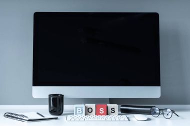 bilgisayar ve tahta küpleri ile beyaz masa üzerinde kelime patron