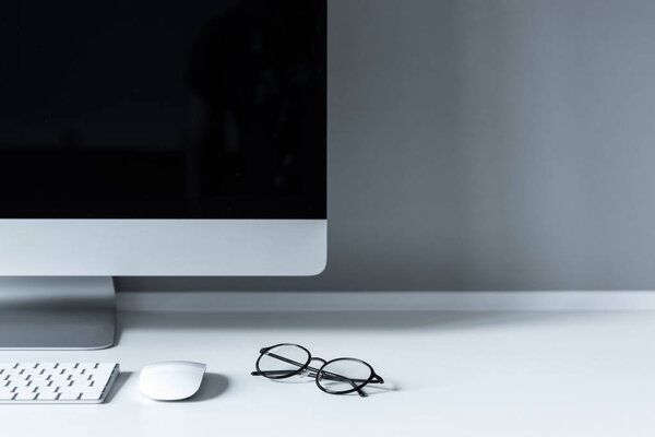 glasses and computer mouse with keyboard on working table
