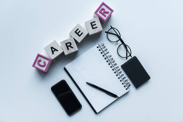 top view of wooden cubes with word Career and notebook with pen on table